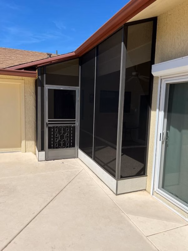 Custom window screen installed on the corner of a house. Security screen door installed alongside.