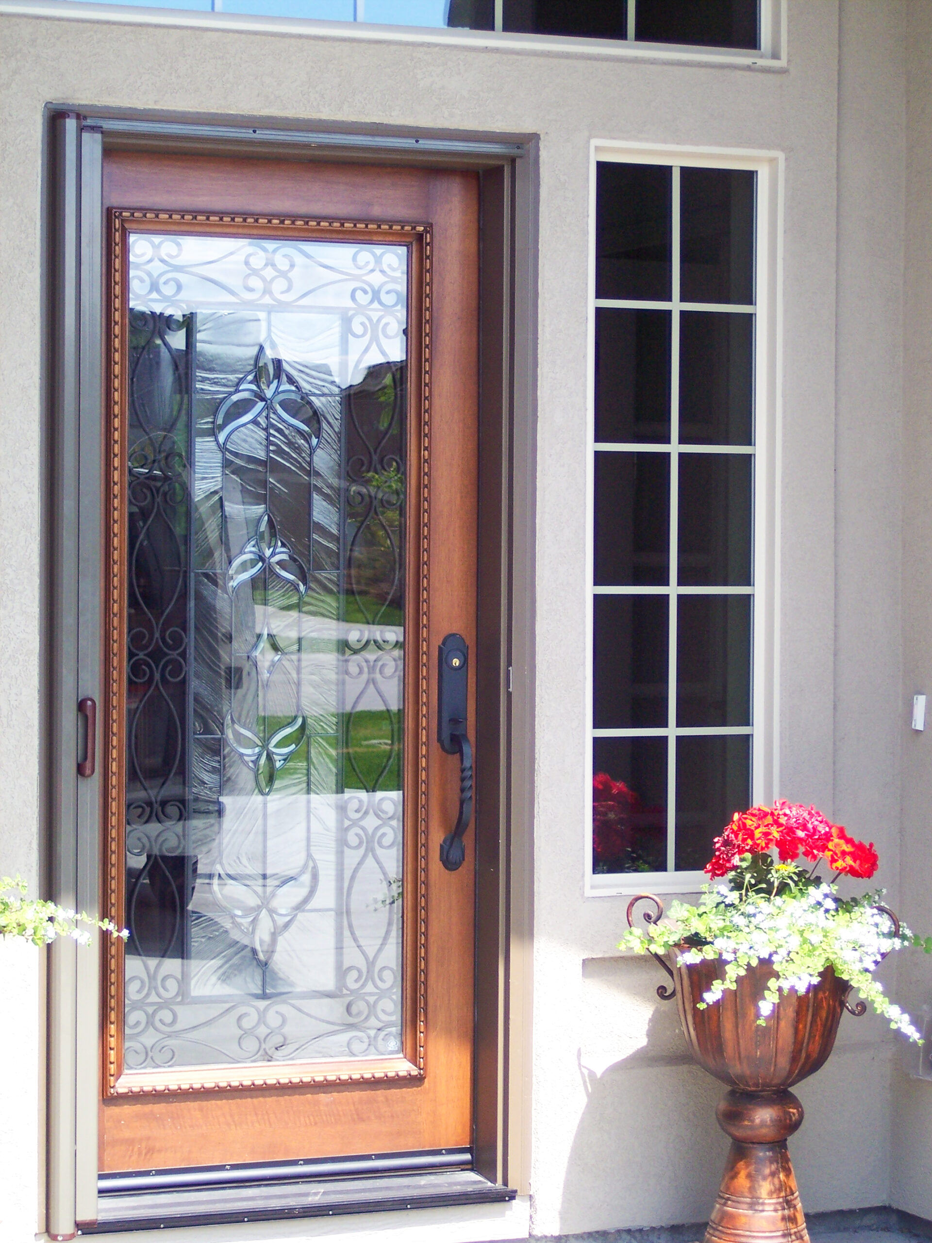 Custom window screen installed on the corner of a house. Security screen door installed alongside.