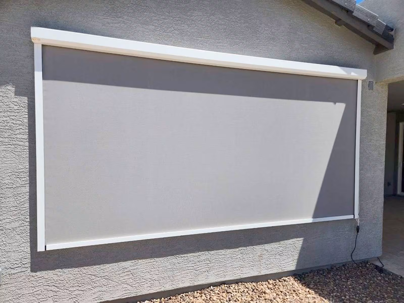 roll down shade installed on a white peoria home on a sunny day.